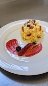 a white plate with a dessert with fruit on it at Agriturismo La Part in San Zeno di Montagna