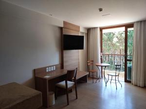 een hotelkamer met een bed en een tafel met stoelen bij Flat Hotel Pedra Azul in Pedra Azul
