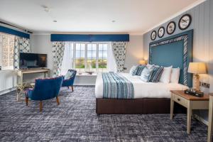 布莱克尼The Manor Coastal Hotel & Inn, Blakeney - The Coaching Inn Group的配有一张大床和一台电视的酒店房间