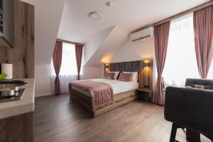 a hotel room with a bed and two windows at Casa ARTEE Free Parking in Sarajevo