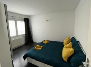 a bedroom with a blue bed with yellow pillows at Appartement Tourbillon centre-ville in Sion