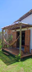 a porch with a hammock and a house at Casa Tatuí in Pôrto de Pedras
