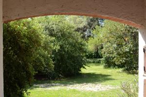 un arco en un jardín con árboles y césped en Hospedajes Serranos, Cabañas Aaron, solo acepto reservas por privado en Villa Las Rosas