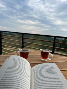 een open boek op een tafel met twee kopjes koffie bij Hotel Med Doradal in Doradal