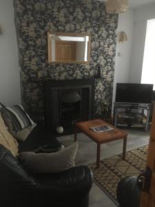 a living room with a fireplace and a couch and a table at Derry City center townhouse in Derry Londonderry