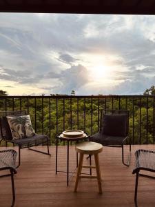 a patio with two chairs and a table and a view of a field at Appartement NOAM, Mont Choisy in Mont Choisy
