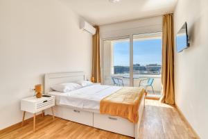 1 dormitorio con 1 cama y balcón en Ivanovic residences, en Budva
