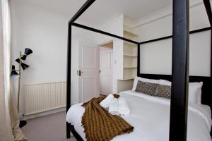 ロンドンにある4 Bed Duplex Garden Viewsのベッドルーム(鏡付きの白黒ベッド1台付)