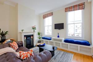 a living room with a couch and a fire place at 4 Bed Duplex Garden Views in London