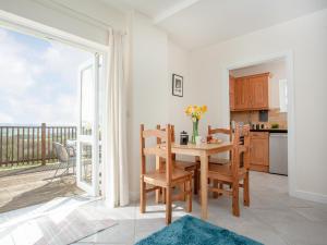 a kitchen and dining room with a table and a balcony at Stargazer - Uk43267 in Luppitt