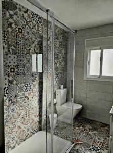 托雷莫利諾斯的住宿－Villa Musica，一间带卫生间和玻璃淋浴间的浴室