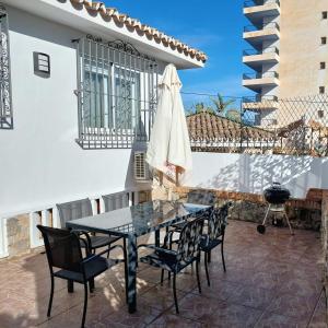 a patio with a table and chairs and a grill at Villa Musica in Torremolinos