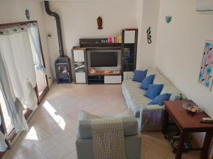 sala de estar con sofá y TV en Villa Cala Sinzias, en Castiadas