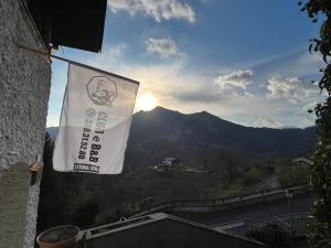 a flag hanging from the side of a building with a mountain at Camera matrimoniale con terrazza panoramica in Serina