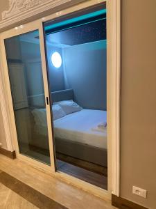 Una puerta de cristal con una cama en una habitación en Imperial Maison Rome en Roma