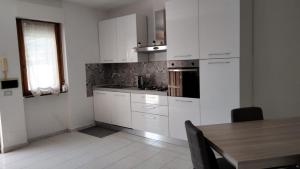 a kitchen with white cabinets and a wooden table at Casa Josè in Marta