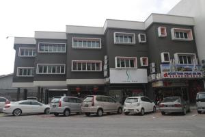 a large building with cars parked in front of it at The Osborne Apartments in Ipoh