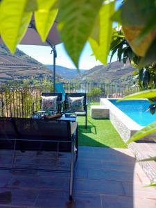 a patio with two chairs and a swimming pool at Casa Nunes in Pinhão