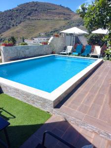 a swimming pool with blue water in a yard at Casa Nunes in Pinhão