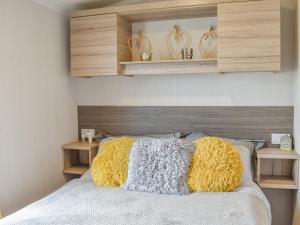a bedroom with a bed with two yellow pillows at Seaview 1 in Heysham
