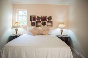 a bedroom with a large white bed with two lamps at Seawind Beach Apartments in Montego Bay