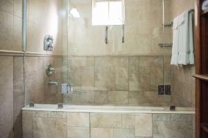 a bathroom with a shower with a tub at Seawind Beach Apartments in Montego Bay +22 photos