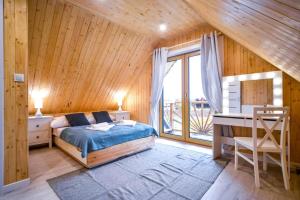 - une chambre avec un lit, un bureau et une fenêtre dans l'établissement Nini House Dudki, à Giże