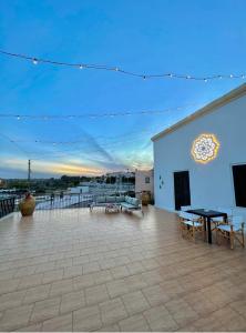 un patio avec des tables et des bancs dans un bâtiment dans l'établissement Terrazza Levante, à Otrante