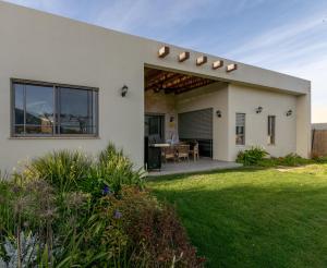 una casa bianca con un patio e un prato di Our Mount Meron Orchard - your perfect getaway a Tsiv'on