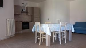 a kitchen with a table with chairs and a blue couch at RESIDENZA MICHI in Gravedona