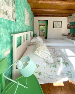 a bedroom with a large bed with green walls at Casa delle Arti Fattoria dei fiori in Sospirolo