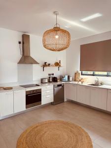 a kitchen with white cabinets and a chandelier at Appartement NOAM, Mont Choisy in Mont Choisy