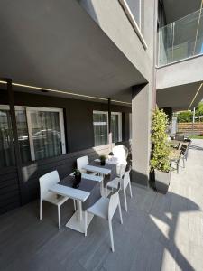 a group of tables and white chairs on a patio at Apparthotel Ardea in Riccione