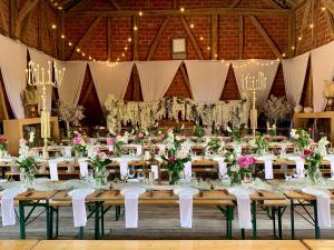 - une salle de banquet avec des tables, des chaises et des fleurs dans l'établissement Le Domaine du Lavoir, à Villemoiron-en-Othe