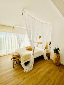 een slaapkamer met een hemelbed bij Caparica Rooftop Beach Apartment in Costa da Caparica