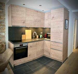 a kitchen with wooden cabinets and a stove at Spacious 3 Room Apartment - Family-Friendly - Central Leukerbad - Great Views in Leukerbad