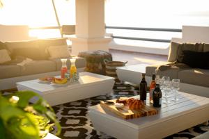 布塞里亞斯的住宿－Villa Cobojo，客厅配有沙发和带葡萄酒瓶的桌子