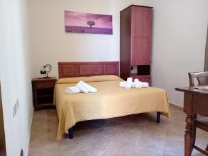 1 dormitorio con 1 cama con toallas en Agriturismo Ponte Due Archi, en Raccuia
