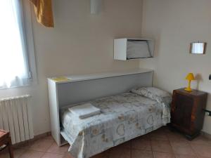 een kleine slaapkamer met een bed en een magnetron bij Agriturismo Alla Casella in Ferrara