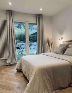 a bedroom with a large bed and a large window at Chambre indépendante avec sdb et toilettes privées dans une maison en forêt proche du golf et de la plage Entree indépendante avec acces privé in Le Touquet-Paris-Plage