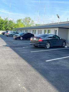 uma fila de carros estacionados num parque de estacionamento em Broadway Inn Motel em San Antonio