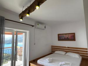 a bedroom with a bed and a balcony at Argileos Rooms in Himare