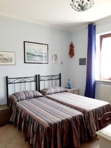 Manziana的住宿－La Casa Più Sù，一间卧室设有两张床和窗户。