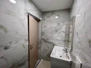 La salle de bains blanche est pourvue d'un lavabo et d'une douche. dans l'établissement Argileos Rooms, à Himarë