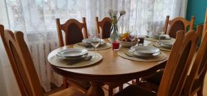 uma mesa de madeira com pratos e copos em Apartament rustykalny em Jelenia Góra