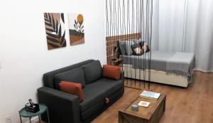 un soggiorno con un divano e un letto di Apezinho.Loft 3 (Retrô) a Rio de Janeiro