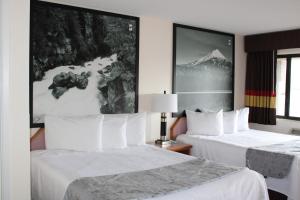 um quarto de hotel com duas camas com lençóis brancos em Scottish Inns Ashland em Ashland