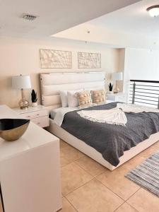 a white bedroom with a large bed with pillows at Sublime Views 2BR double balcony loft in Miami
