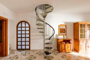 uma escada em espiral num quarto com uma mesa e um espelho em Villa Sofia em Praiano