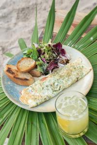 a plate of food with bread and salad and a drink at Astral Tulum in Tulum